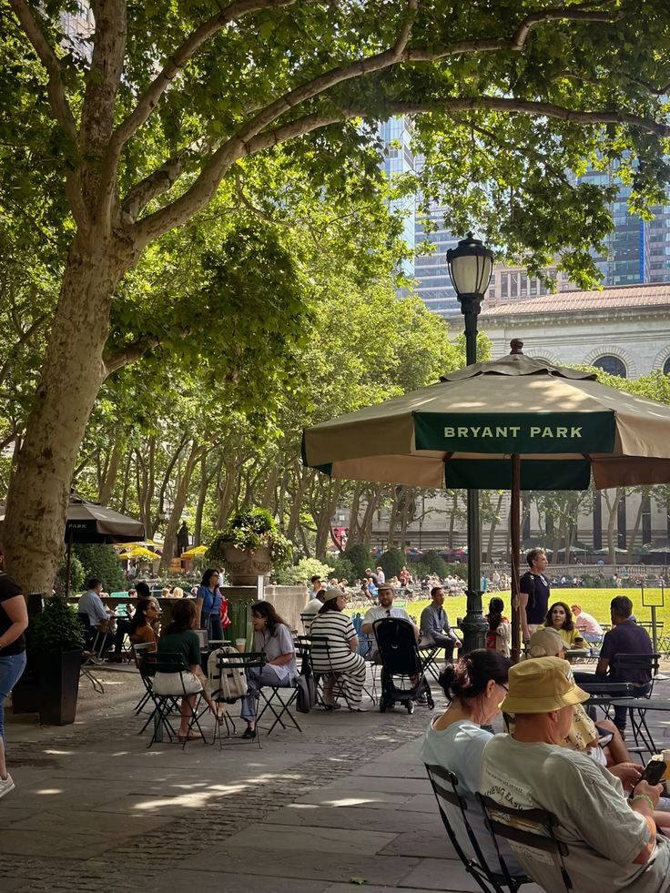 Terrasse de Bryant Park à Manhattan : chaises de parc, parasols et grands arbres